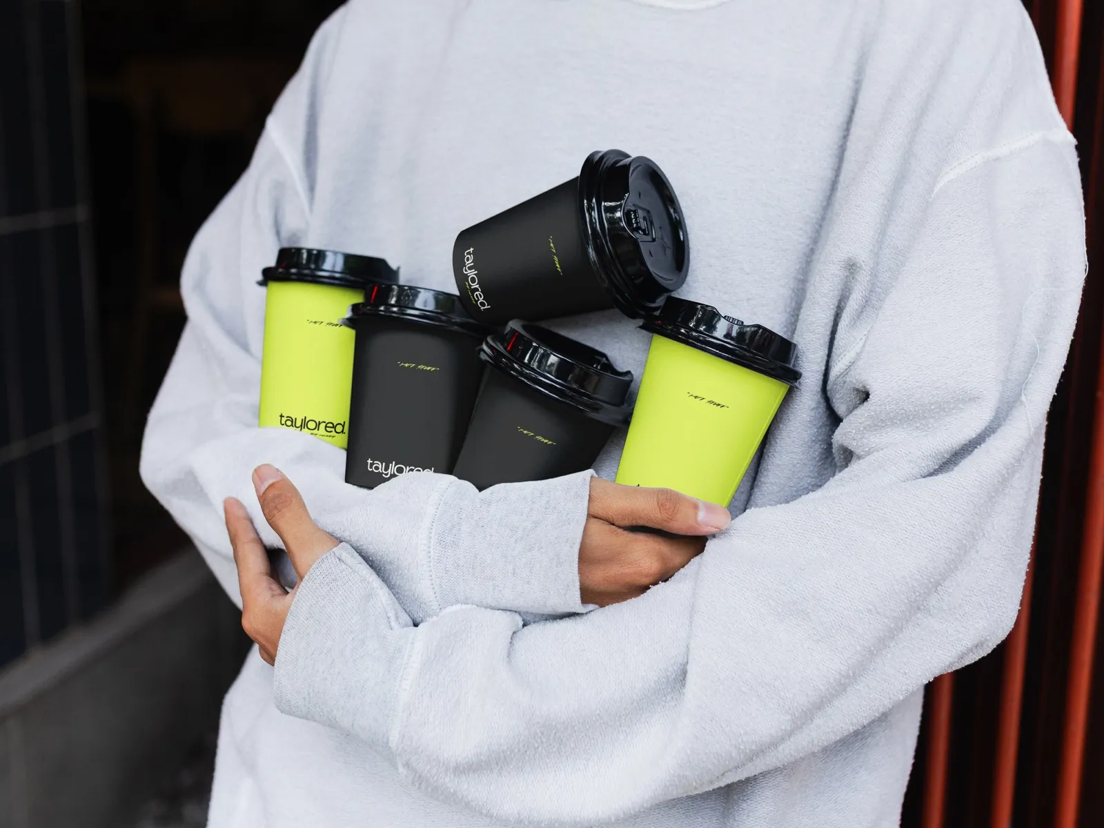 Taylored Barbering takeaway cups, held in the wild